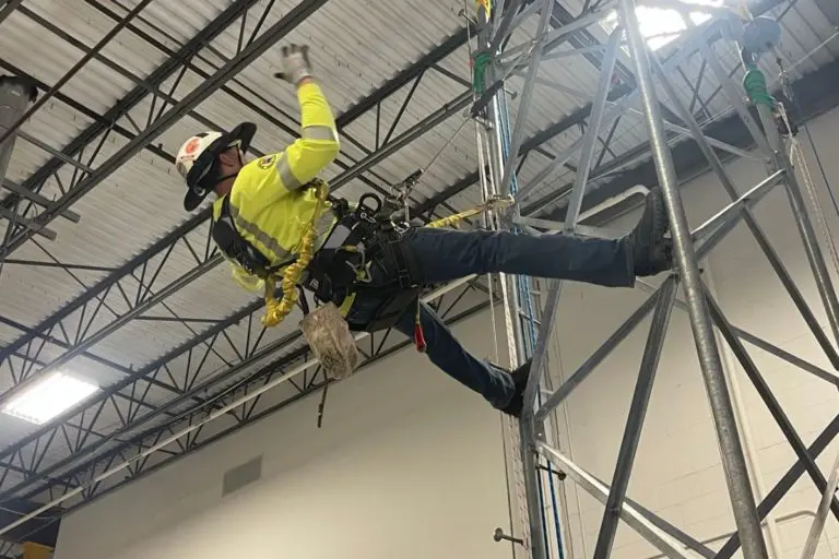 Worker hanging from metal structure