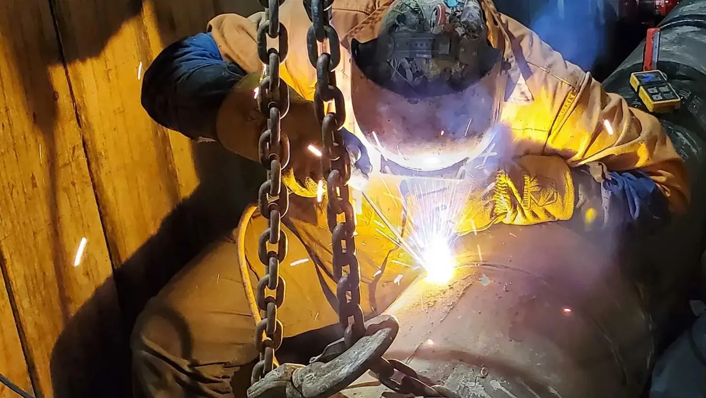 Worker welding pipe