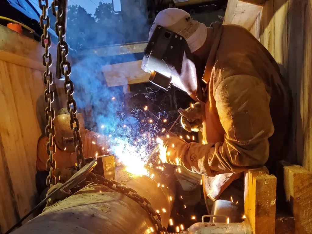 Person welding pipe