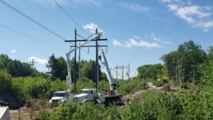 Workers rebuilding transmission line poles