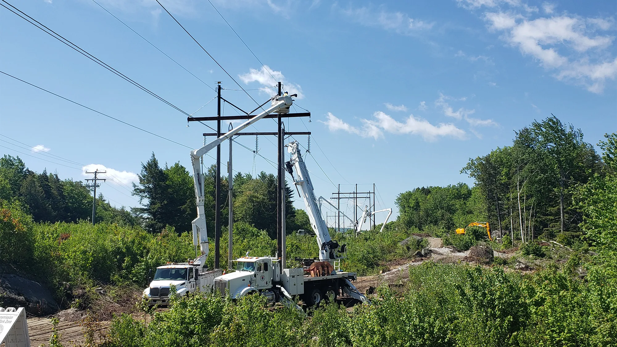 Workers rebuilding transmission line poles