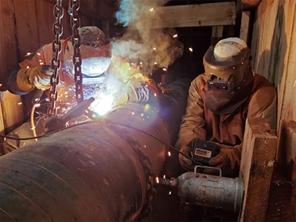 Men welding pipes