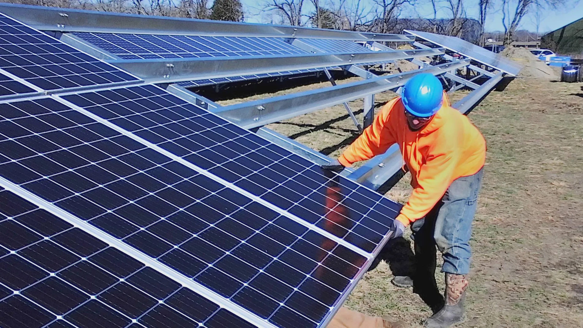Worker moving solar panels