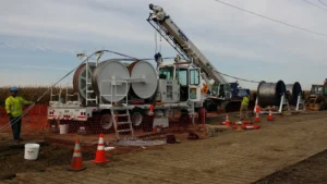 Workers with large rolls of transmission line