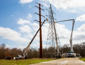 Photo of a transmission line being rebuilt using bucket trucks