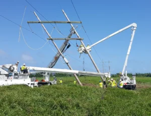 Workers using bucket trucks to fix downed power lines during hurricane cleanup