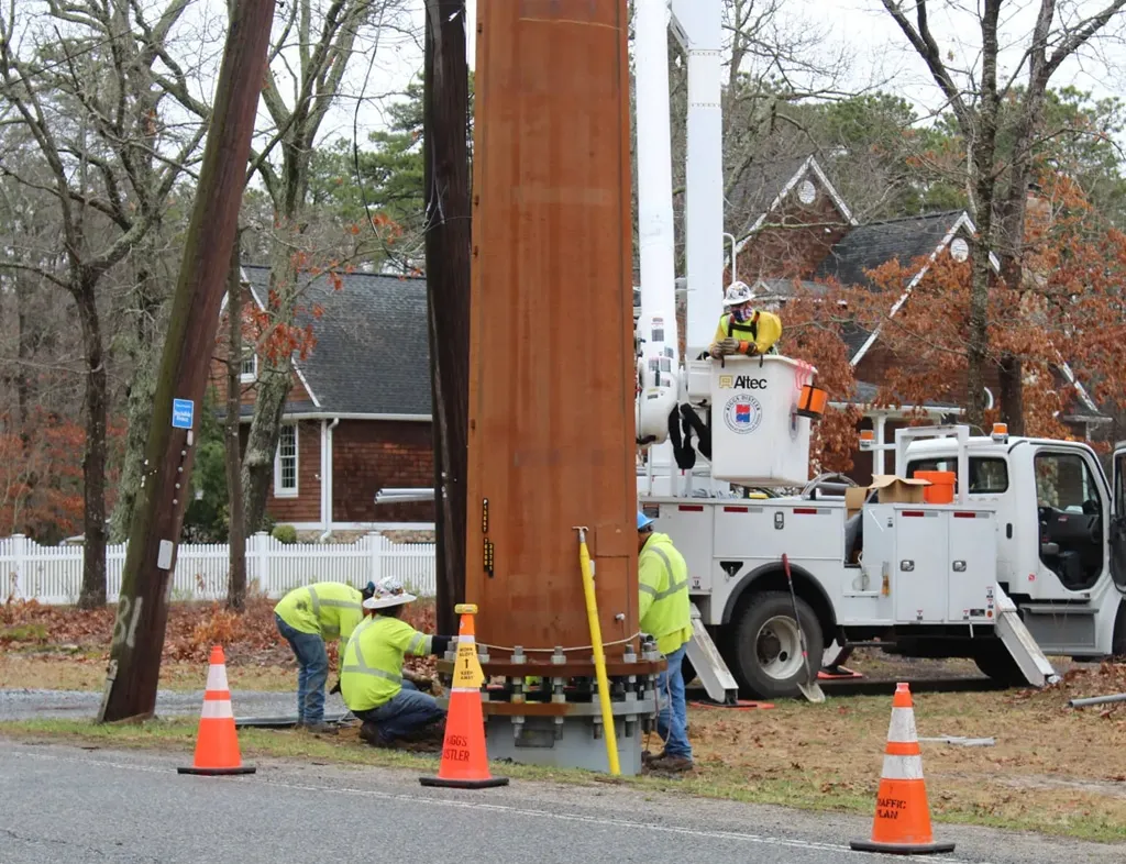 Workers at base of transmission pole