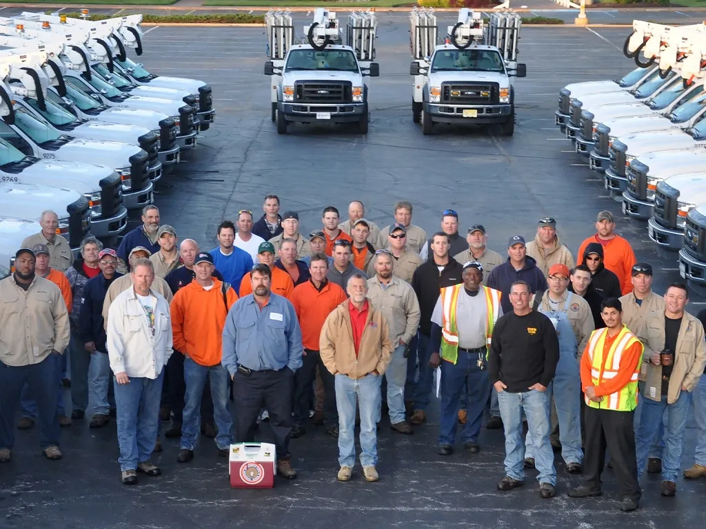 Team photo in front of trucks